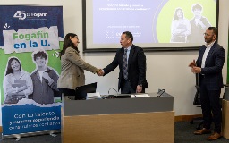 Dos personas dándose la mano después de haber firmado un acuerdo.
