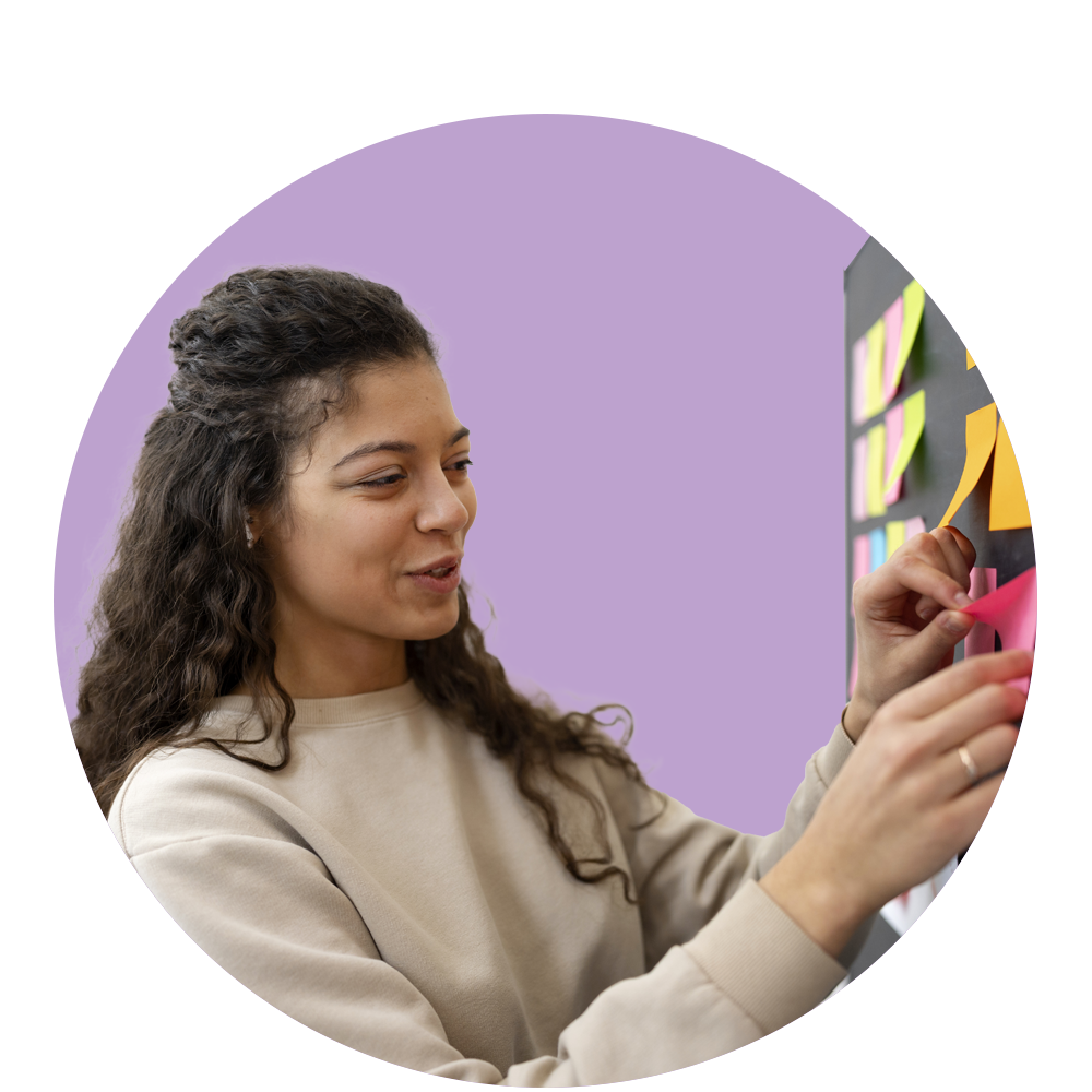 Mujer sonriendo y pegando post it.