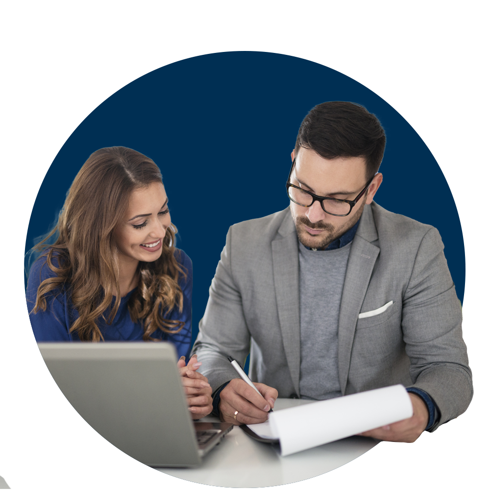 Mujer y hombre revisando laptop y tomando notas en una hoja.